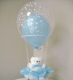 Transparent balloon filled with a single Blue balloon tied to a basket with White Teddy and Blue wrapping
