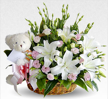 White Liliums and white teddy in a basket